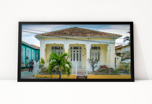 Poster Cuba Villa 1 ingelijst, kleurenfoto van een gele villa met witte zuilen, sierlijke ramen met traliewerk en een palmboom in de voortuin